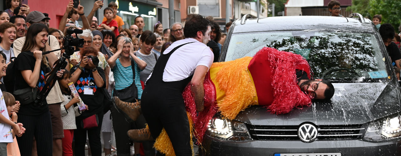 Circus Clown Performance in Car Wash by Agro The Clown. Agro the clown cleaning a car with a human car wash roller. Luca Della Gatta