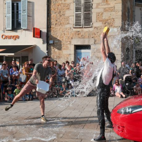 Car wash by Agro the Clown. Agro receiving a bucket of water from a spectator. Luca Della Gatta