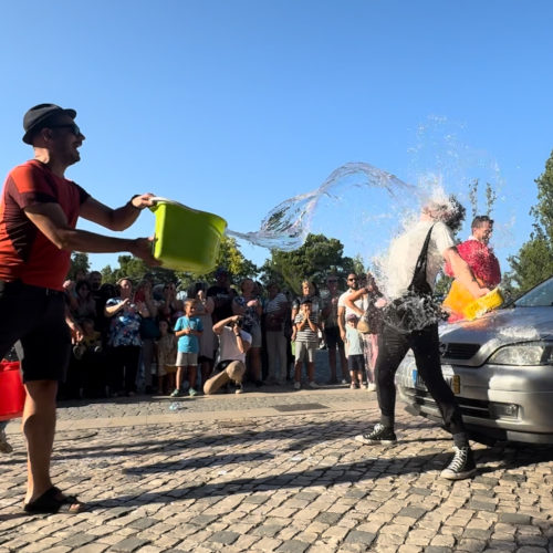 Car wash by Agro the Clown. Agro receiving a bucket of water from a spectator. Luca Della Gatta. Luca Della Gatta