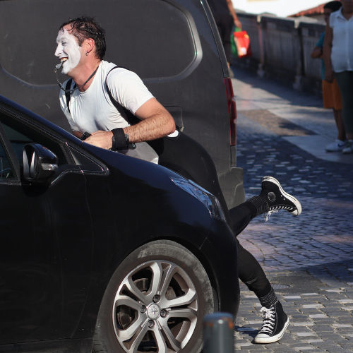 Car Wash clown performance. Agro the Clown leaning on a car. Luca Della Gatta