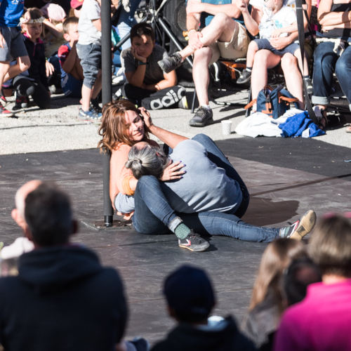 Laisse-moi is a contemporary circus on Chinese mast. Miguel Rubio and Nely Carrasco embracing on the floor next to the Chinese mast